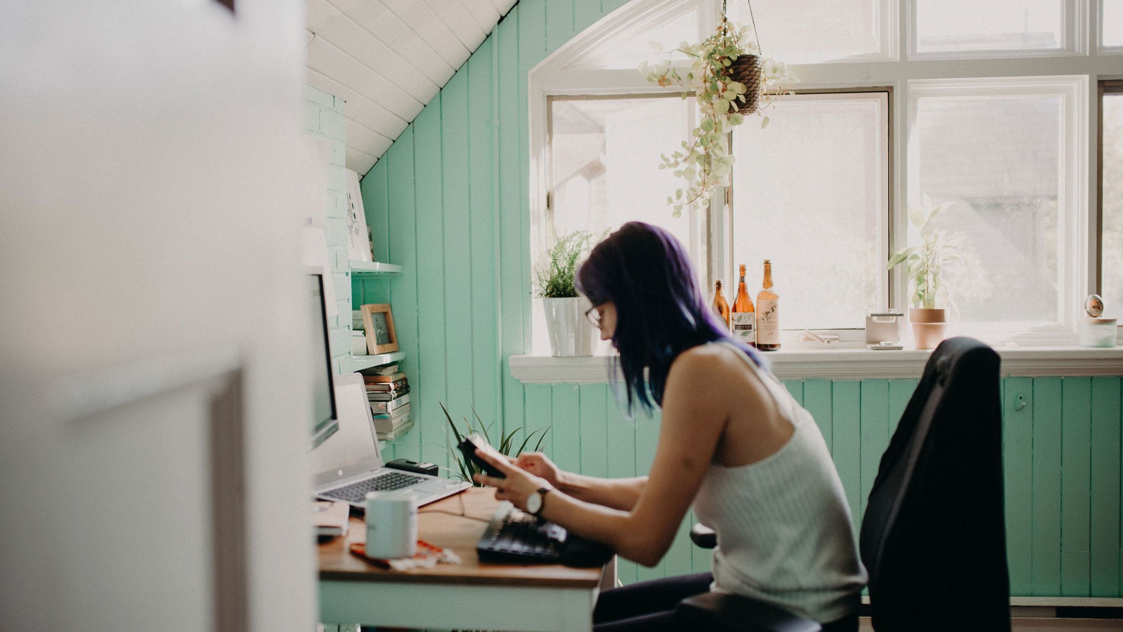 violet-haired woman sitting and using her iPad